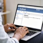 Employe tapant un message d absence sur Outlook