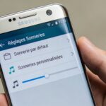 main tenant un smartphone samsung affichant ecran reglages sonneries