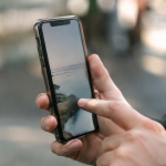 Doigt appuyant sur ecran tactile smartphone tenu verticalement