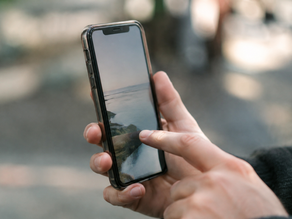 Doigt appuyant sur ecran tactile smartphone tenu verticalement
