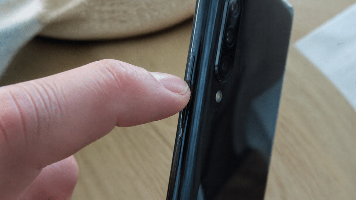 Doigt appuyant sur bouton reinitialisation telephone android xiaomi