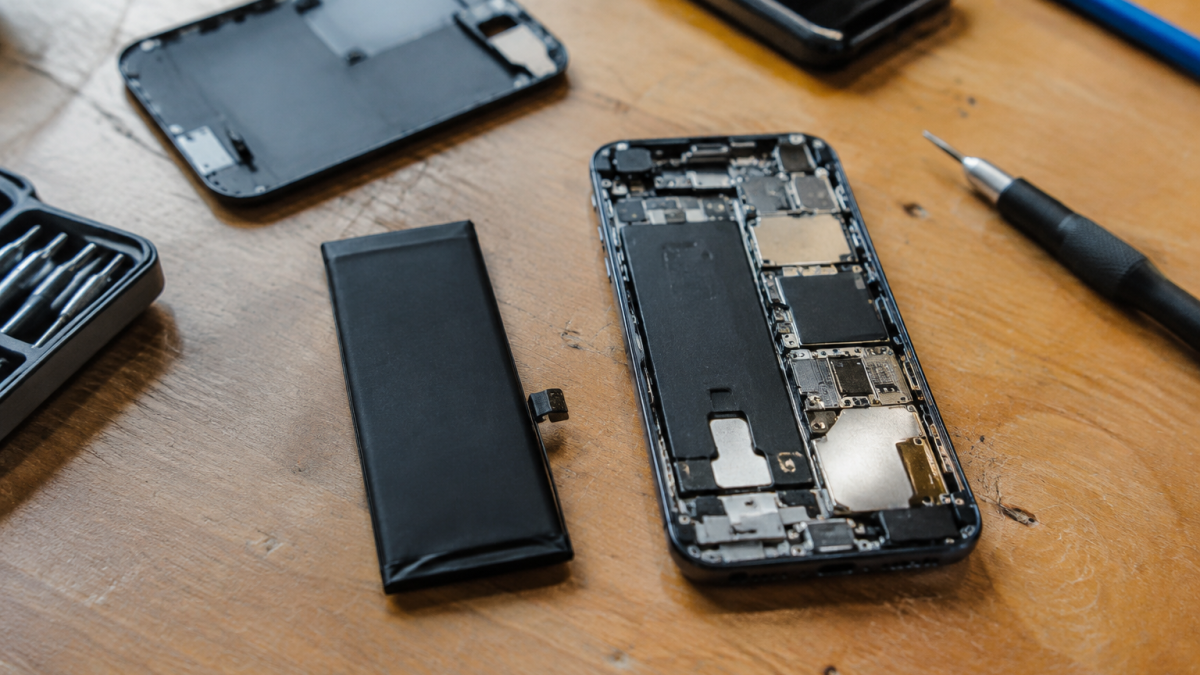 main tenant batterie de iphone demonte sur etabli