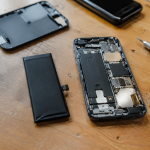 main tenant batterie de iphone demonte sur etabli