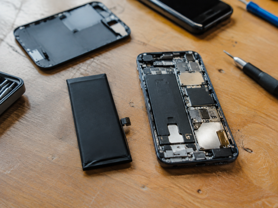 main tenant batterie de iphone demonte sur etabli
