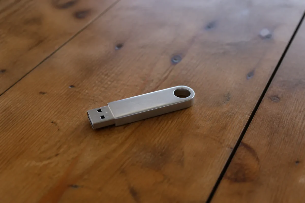 Cle USB argentee posee sur table en bois