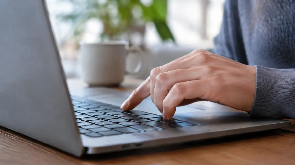 Main appuyant sur une touche du clavier portable
