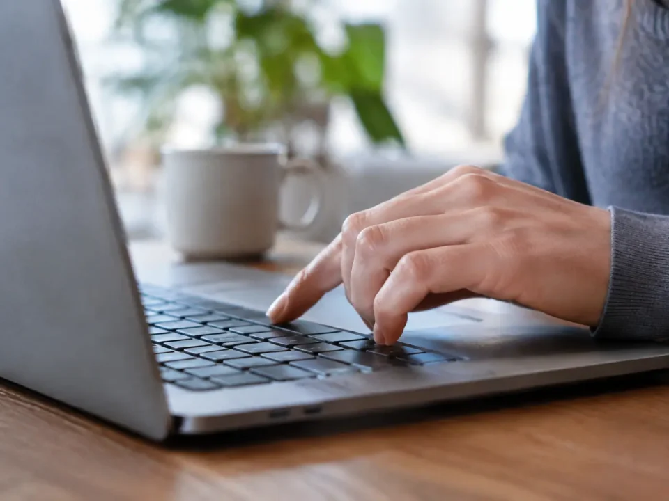 Main appuyant sur une touche du clavier portable
