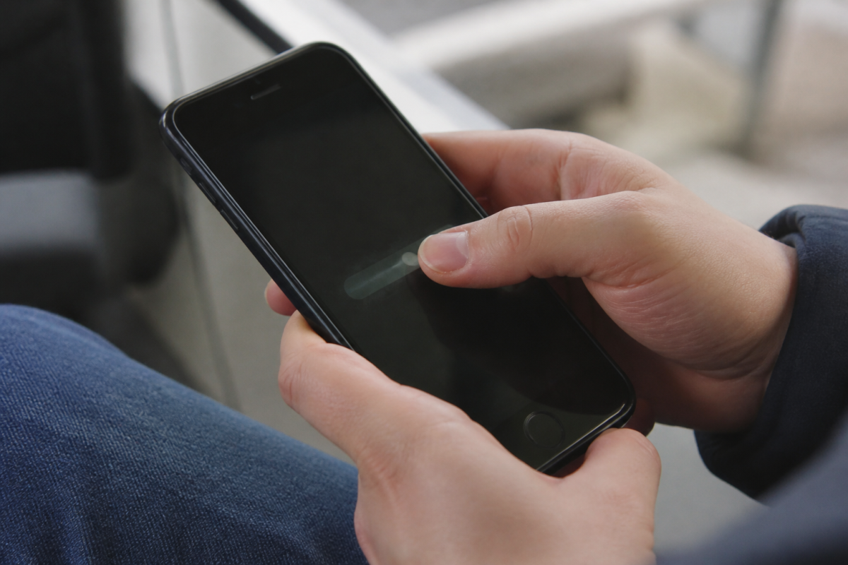 Pouce faisant glisser le curseur gris sur smartphone noir