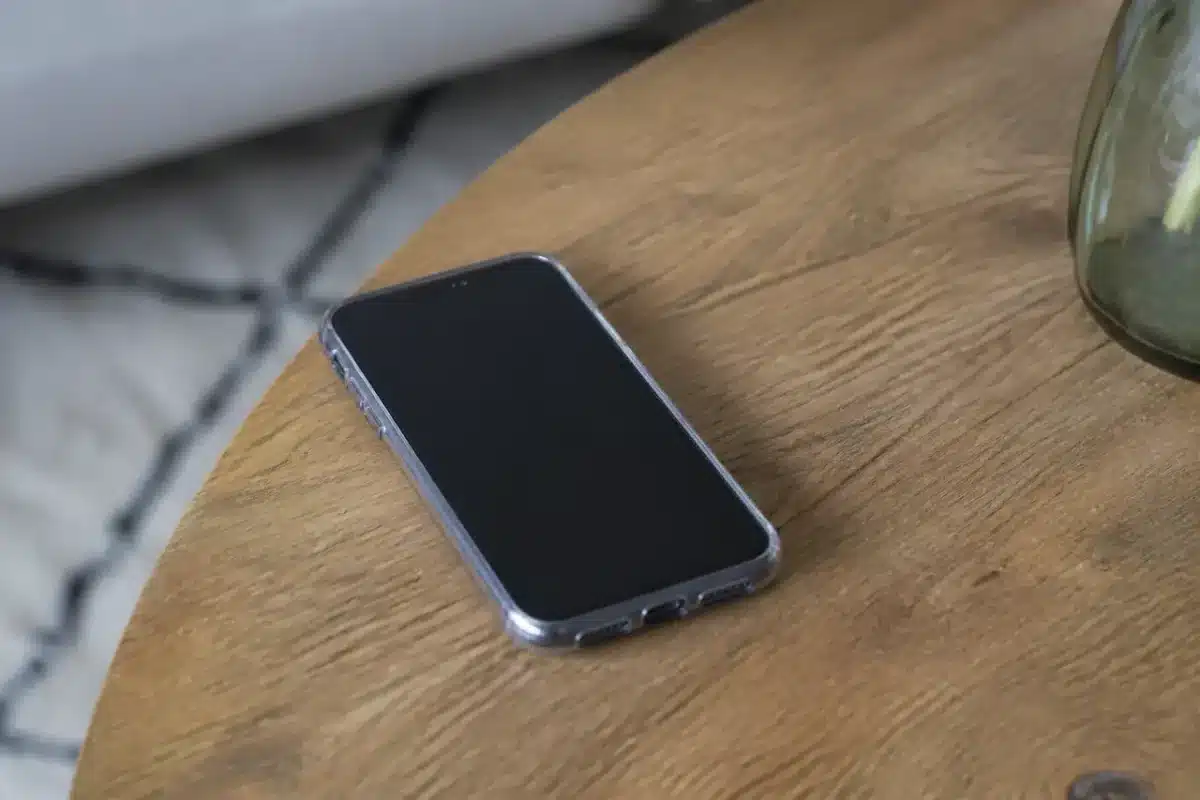 Smartphone noir dans coque transparente sur table en bois