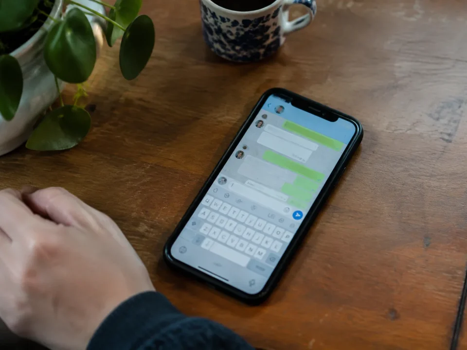 Smartphone pose sur table, ecran affichant une messagerie ouverte